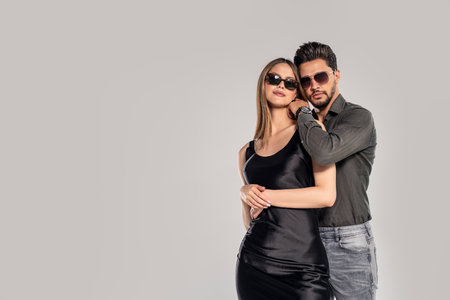 Fashion photo of handsome young couple posing in sunglasses. Studio shot. Personal accessories.Copy space.の写真素材