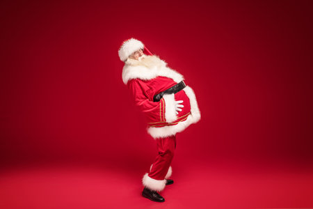 Funny santa claus on red studio backgroundの写真素材