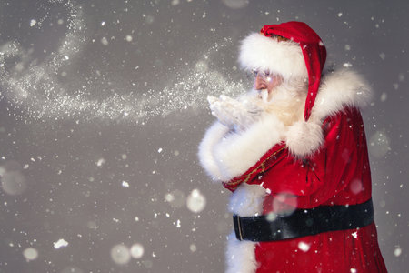 Magical photo of real Santa Claus blowing in snow. Merry Christmas and Happy New Year! Xmas is coming.の写真素材