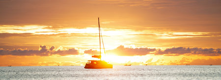 Sailboat and long boats at sea. Seascape during golden sunset . Nature . Thailand, Asia.