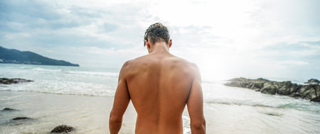 Handsome young muscular italian man posing shirtless on the beach, summer time. Ideal fit body. Back...