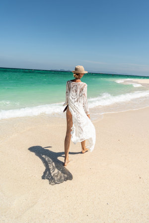 summer holiday. Carefree joyful woman walking on white sand, relaxing and enjoying tropical beach. Traveler. tourism. Wanderlust.の写真素材
