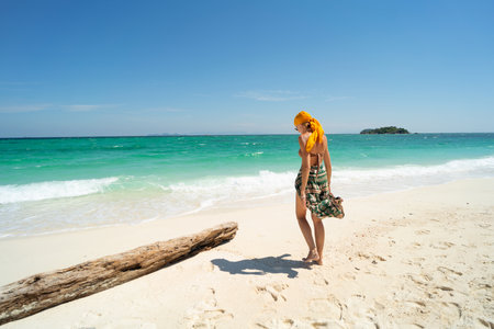 summer holiday. Carefree joyful woman walking on white sand, relaxing and enjoying tropical beach. Traveler. tourism. Wanderlust.の写真素材