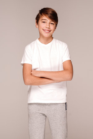 Portrait of smiling, happy teenage boy in a white tshirt posing isolated on light gray studio background. Concept of sincere emotions. real people.の写真素材