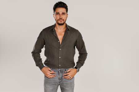 Handsome man with beard, in casual clothes, posing isolated on light studio background. copy space.の写真素材