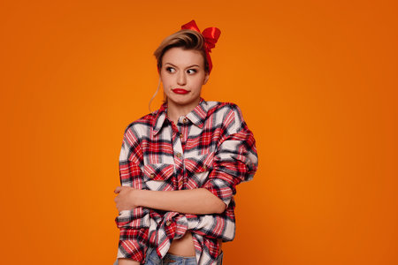 Young girl with shocked,surprised expression, isolated on orange studio background. A lot of copy space. Real people emotions.の写真素材