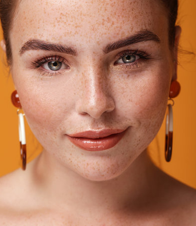 Beauty closeup portrait of charming ginger young woman with natural freckles. Girl looking at the camera.の写真素材