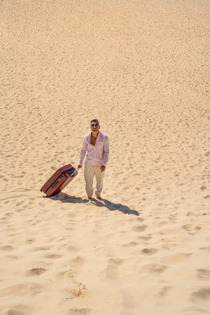 Man with suitcase walking in a desert. A lot of copy space. concept photo. tourism. Traveler.の写真素材