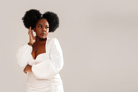 Beauty portrait of attractive woman with afro hairstyle and delicate makeup looking away, posing over studio background. Girl with long lashes .Copy space.の写真素材