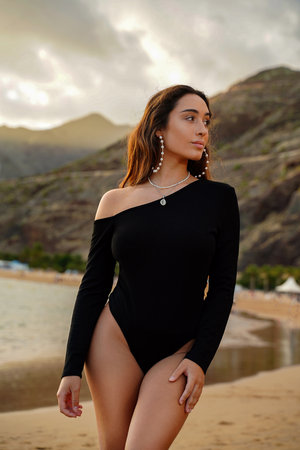 Fashionable female model, beautiful brunette posing on tropical beach. Luxurious lifestyle.の写真素材