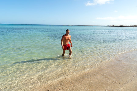 Attractive muscular athletic man in the ocean. Summer vacation. Sunny day. Tourism.の写真素材