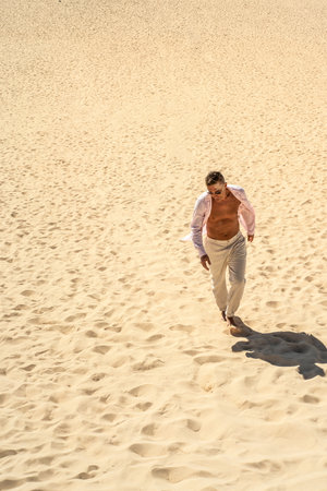 Handsome man walks through the desert at sunny day. A lot of copy space. Tourist. Traveler.の写真素材