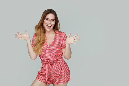 Crazy happy girl posing on grey studio background, laughing and looking at the camera, A lot of copy space.の写真素材