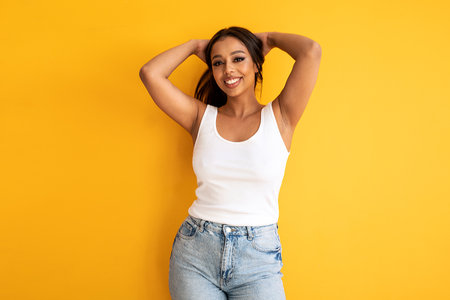 Happy young woman smiling. Beauty female portrait. Real human emotions, facial expression concept. A lot of copy space. Yellow studio background.の写真素材