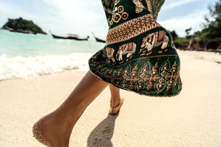 Closeup photo of woman's feet walking on sandy beach. Detail. Asia. Thailand. Summer vibes. Traveler.の写真素材