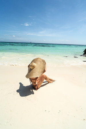 Beautiful woman sunbathing and relaxing at amazing tropical beach in a sunny summer day. Koh Lipe island, Thailand, Asia.の写真素材