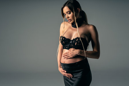 Portrait of beautiful pregnant young woman. Studio shot of a girl who is expecting a baby. Free space for text. Pregnancy concept.の写真素材