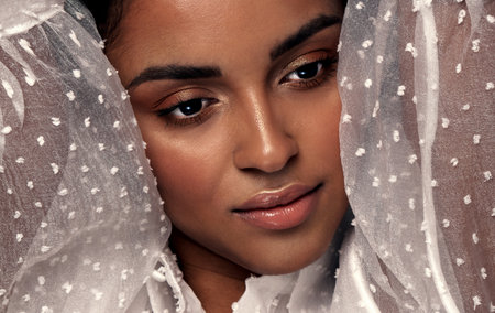 Beauty portrait of attractive afro woman with ideal skin and glamour delicate makeup. Girl wuth beautiful brown eyes. Closeup photo.の写真素材