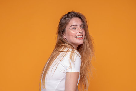Portrait of young attractive ginger woman with freckles on her face. Natural girl smiling to the camera. Studio shot.の写真素材