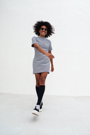 Happy afro american girl laughing and dancing on the street. Real people emotions.の写真素材