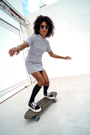 Happy afro american girl with skateboard. Real people lifestyle. Hobby.の写真素材
