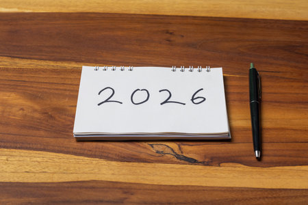 Notebook with the date of the new year on a wooden tableの写真素材