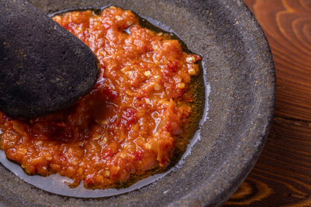 sambal or traditional chili sauce from Indonesia, freshly made using stone mortar and pestleの写真素材