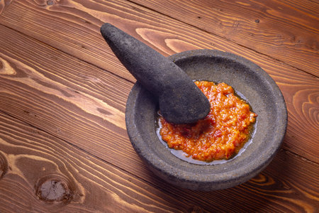 sambal or traditional chili sauce from Indonesia, freshly made using stone mortar and pestleの写真素材