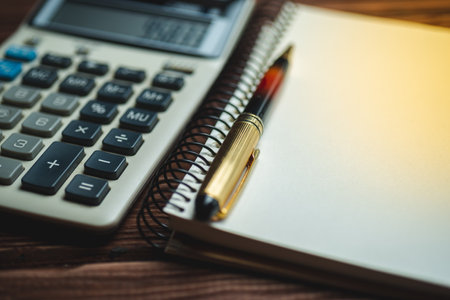 macro shot of calculator, pen and notebook on a wooden background. Concept of business, finance, educationの写真素材