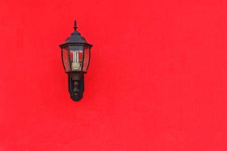 Old Lantern on Red Concrete wall with saving energy bulb, Closeupの写真素材