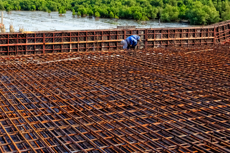 Workers adjusting Steel Rebar for reinforced the concrete bridge at coastal road construction site,...