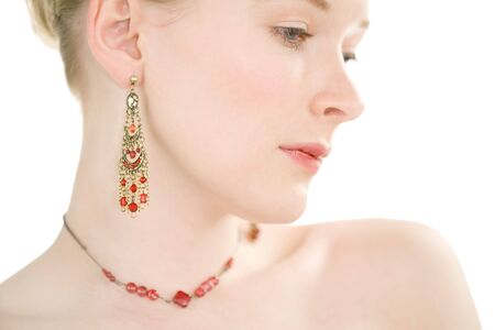 Close up face shot of pale skinned model with red jewelleryの写真素材