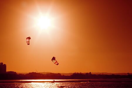 A pair of kite boarders at sunsetの写真素材