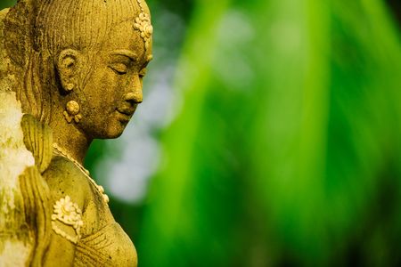 Statue of Asian woman against green foliage backgroundの写真素材