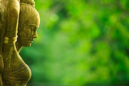 Statue of Asian woman against green foliage backgroundの写真素材