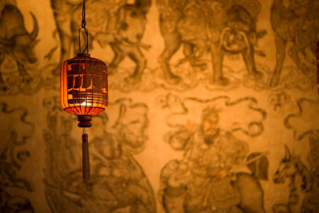 Chinese lantern hangs against Asian wallpaper backgroundの写真素材