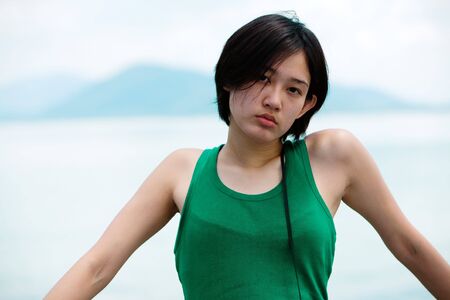 Beautiful Asian woman on holiday with ocean in backgroundの写真素材