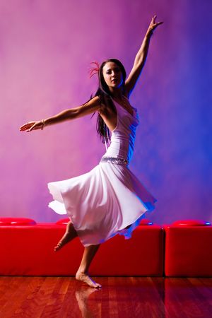 Fashion model spinning in white dress on red and blue background