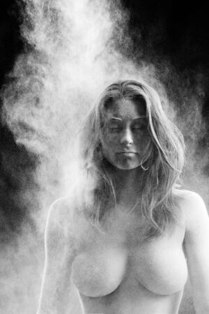 Beautiful girl is covered in white powder, nude with nothing showingの写真素材