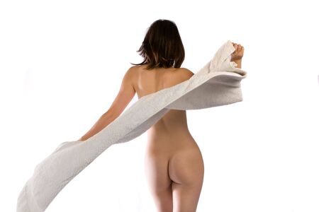 Slim naked woman throws white towel around herの写真素材