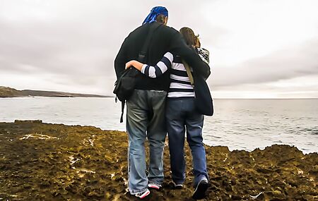 A couple of adults looking at the oceanの写真素材