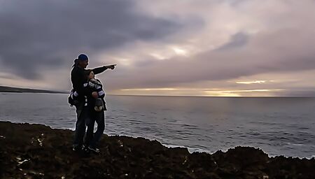 A couple of adults looking at the oceanの写真素材