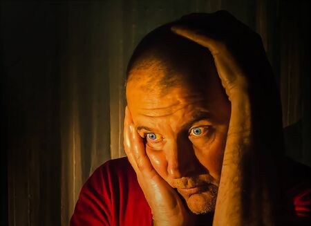 Portrait of a man in the dark with ambient light