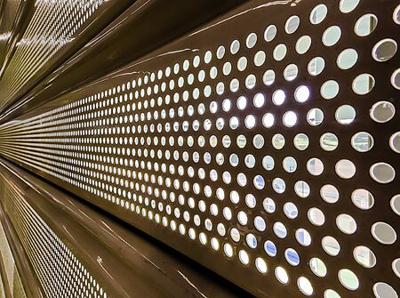 Behind a perforated metal blind in perspectiveの写真素材
