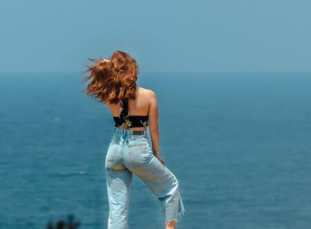 A young girl caught on the beach posing in front of her friendの写真素材