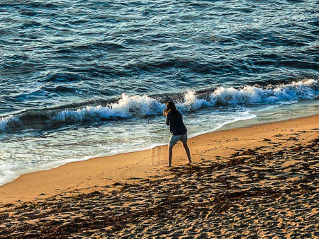 Seascape at sunset close to the blue hour with the sun emanating rays and the golden skyの写真素材