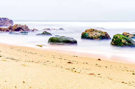 Ocean landscape with a rocky beach with neutral density filter with wide exposureの写真素材