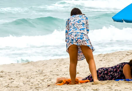 Young girl in flowered dress at the beach preparing for the beachの写真素材
