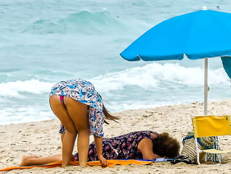 Young girl in flowered dress at the beach preparing for the beachの写真素材