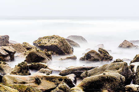 Landscape on the Portuguese coast of the Atlantic Ocean with a rocky beach and cloudy skiesの写真素材